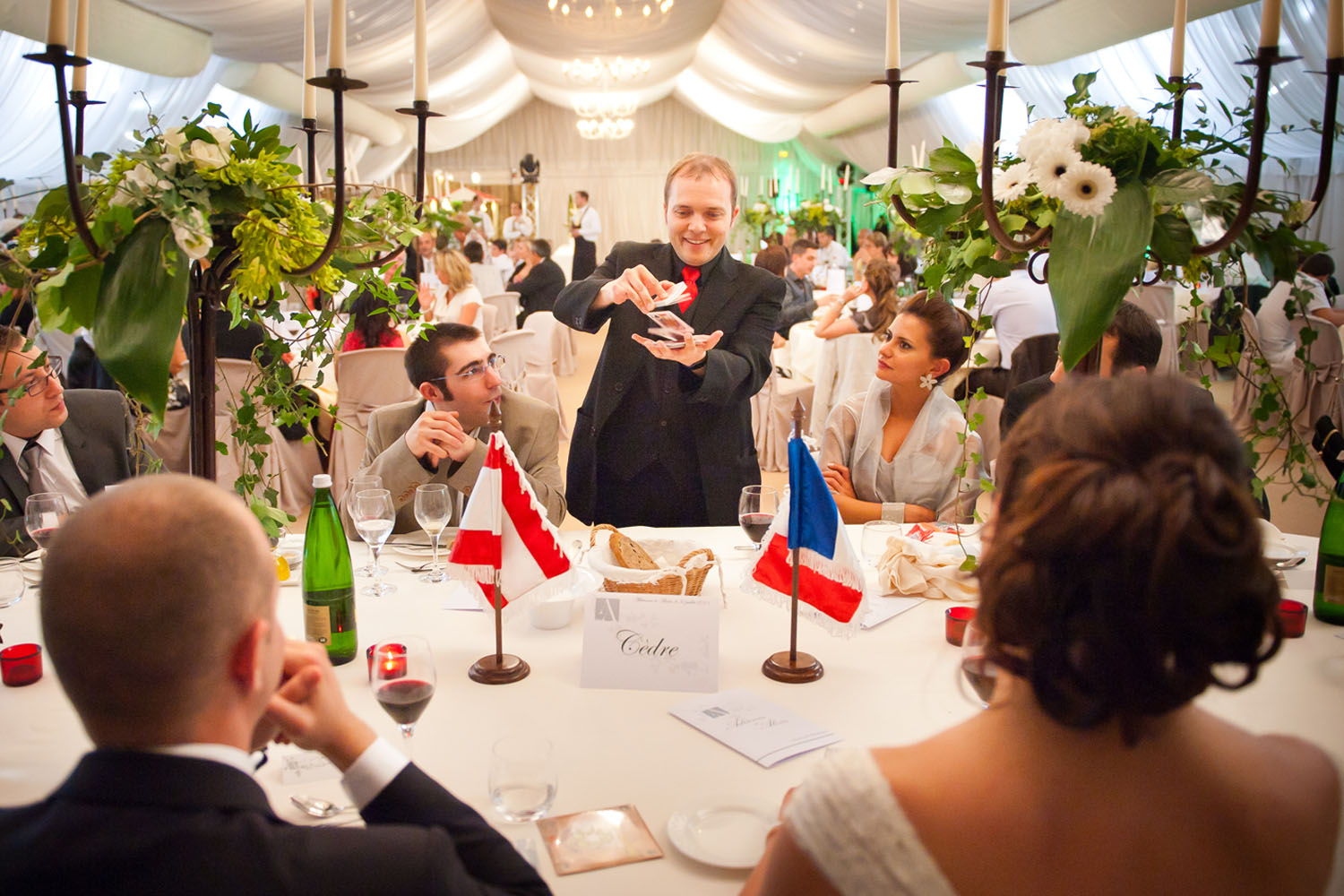 The French magician Boris Wild performing close-up magic at the table of the bride and groom during a wedding