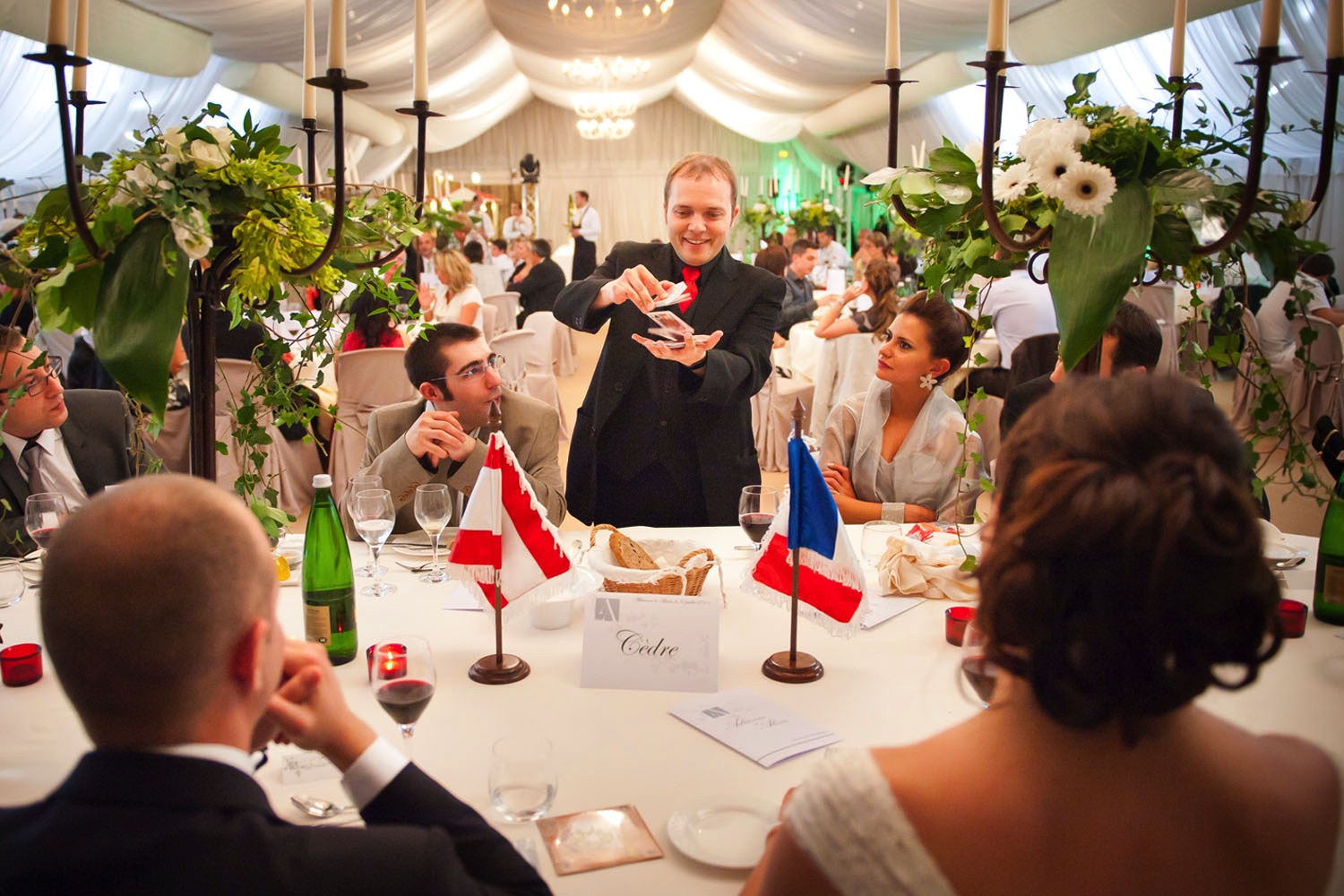The French magician Boris Wild performing close-up magic at the table of the bride and groom during a wedding